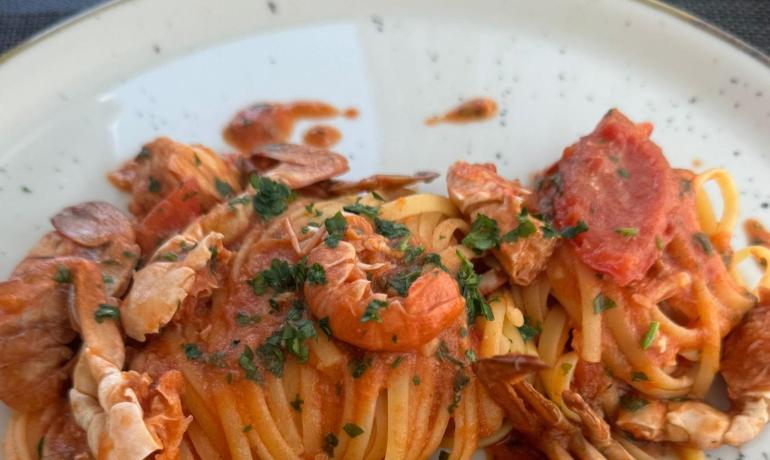 Linguine al granchio con salsa di pomodoro e prezzemolo.