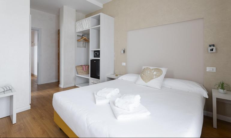 Camera da letto moderna con letto matrimoniale e armadio aperto.