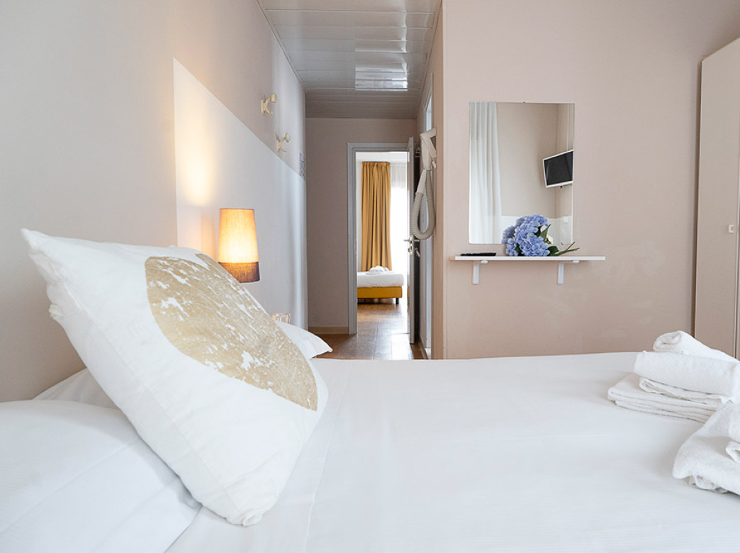 Camera luminosa con dettagli gialli, letto accogliente e arredi moderni.