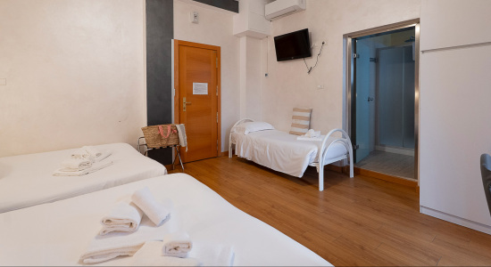 Camera moderna con letto matrimoniale, letti a castello, TV e decorazioni blu.